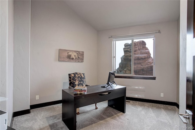 carpeted home office featuring baseboards and lofted ceiling
