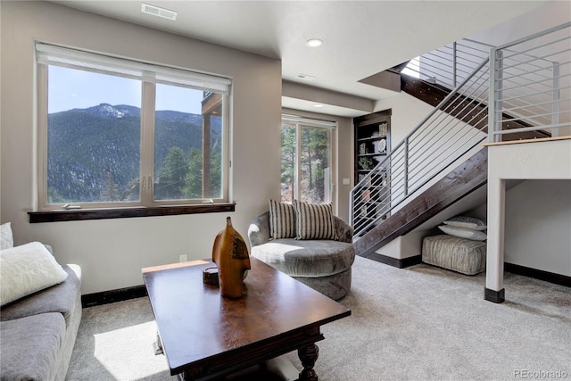 carpeted living area with a mountain view, visible vents, and baseboards
