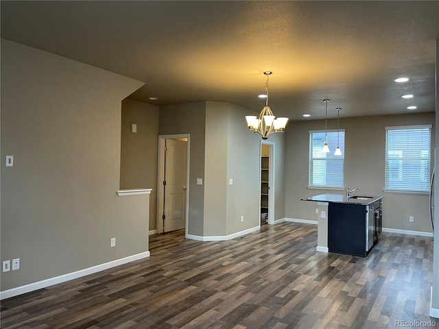 interior space featuring recessed lighting, baseboards, a sink, and dark wood-type flooring