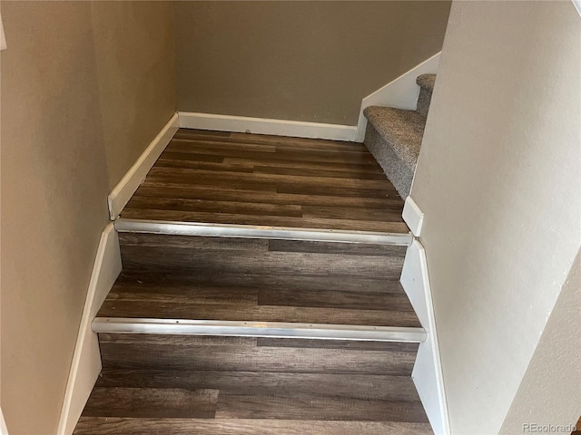 staircase with baseboards and wood finished floors