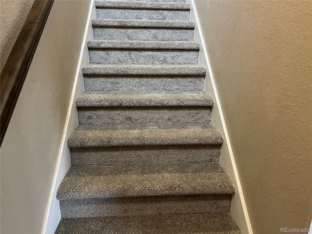 stairway featuring a textured wall