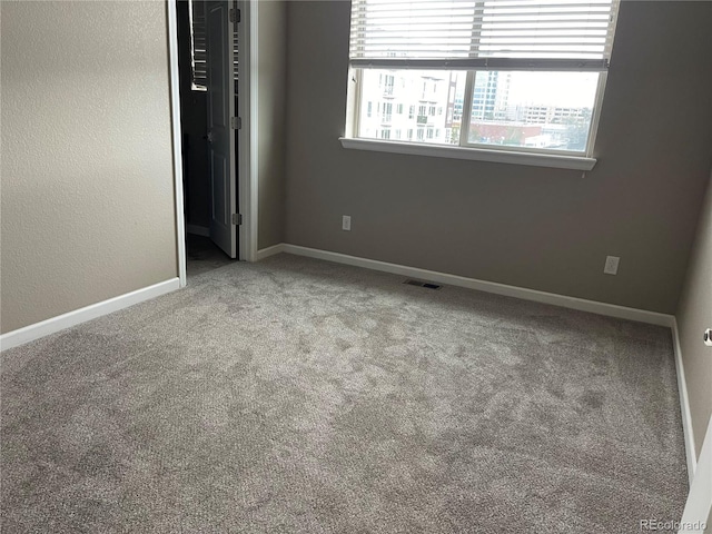 unfurnished bedroom featuring visible vents, baseboards, and carpet floors