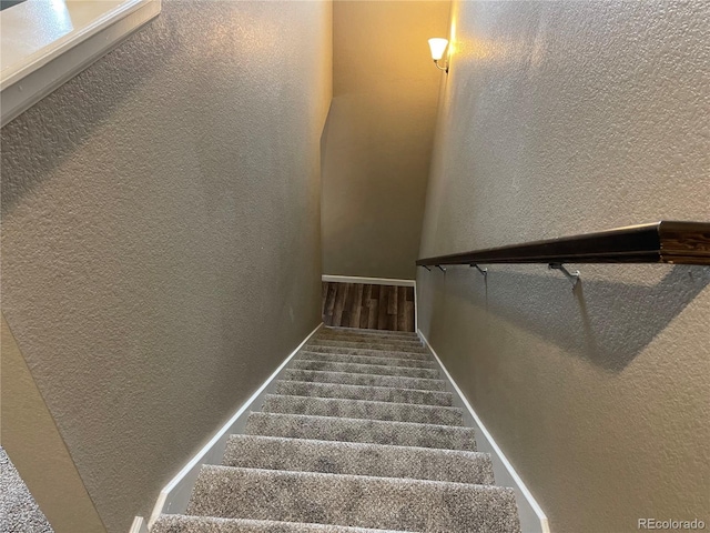 stairway featuring a textured wall