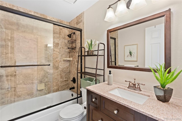 bathroom with vanity, toilet, and shower / bath combination with glass door