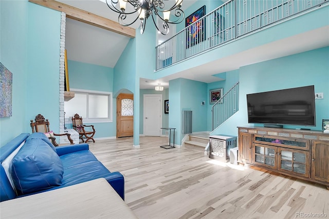 living room featuring high vaulted ceiling, a notable chandelier, beamed ceiling, and light hardwood / wood-style flooring