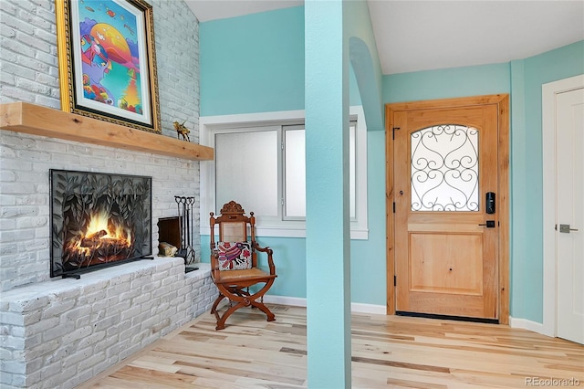 entryway with a fireplace and light hardwood / wood-style flooring