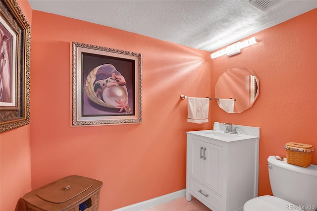 bathroom featuring a textured ceiling, vanity, and toilet