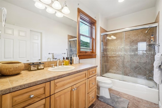 full bathroom with shower / bath combination with glass door, tile patterned flooring, toilet, and vanity