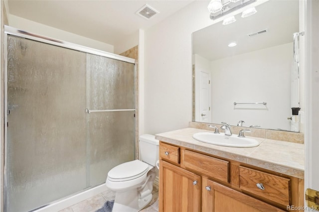 bathroom with vanity, toilet, a shower with shower door, and tile patterned flooring