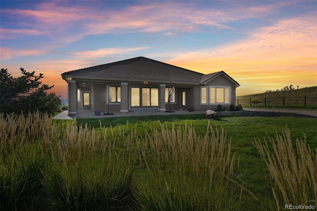 view of front facade with a lawn and a patio