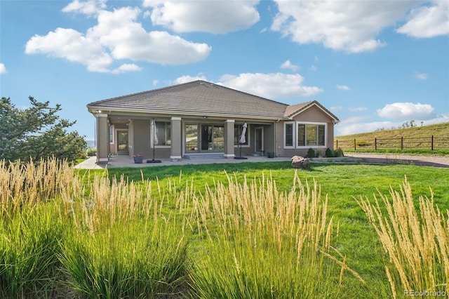 view of front of house with a front lawn, a rural view, and a patio area