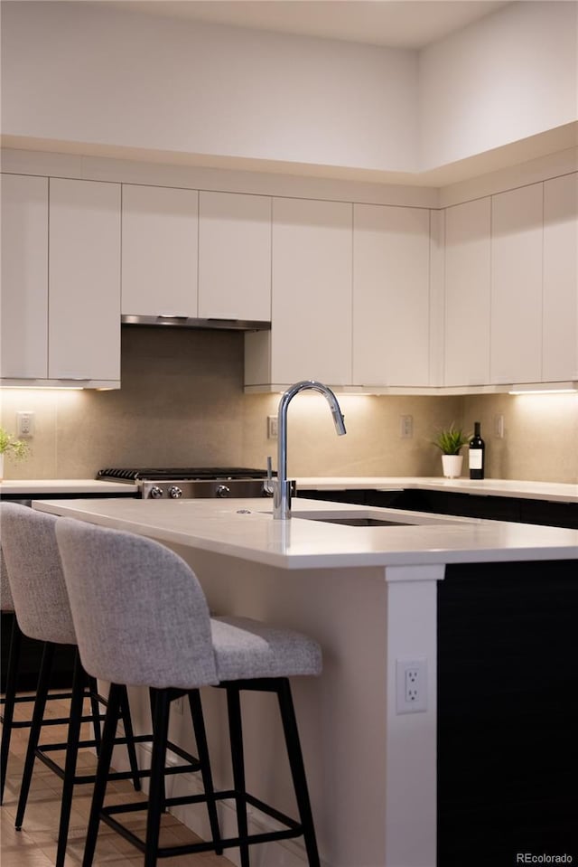 kitchen featuring a kitchen breakfast bar, modern cabinets, and white cabinetry