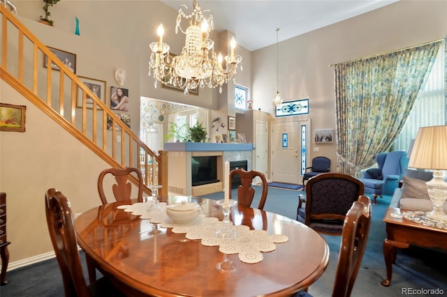 5155 W Quincy Ave Unit L101, Denver, CO 80236 - carpeted dining room featuring a high ceiling, stairway, a tile fireplace, and a chandelier