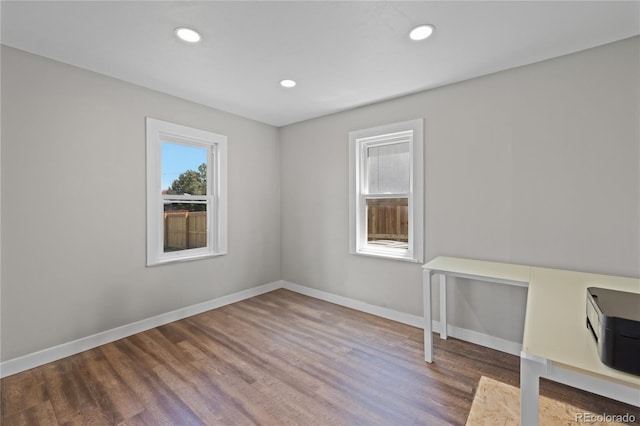 empty room with recessed lighting, baseboards, and wood finished floors