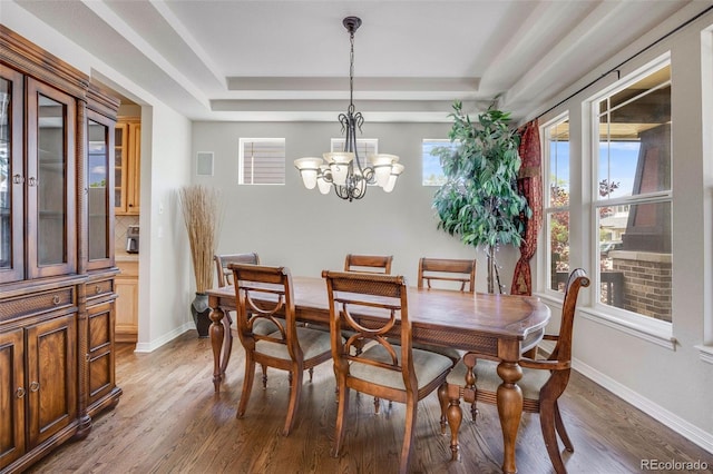 13324 W 86th Dr, Arvada, CO 80005 - dining space with a tray ceiling, wood finished floors, a chandelier, and baseboards
