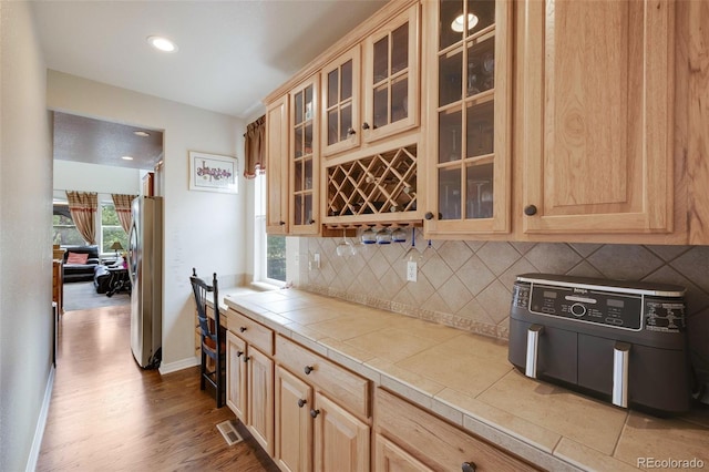 13324 W 86th Dr, Arvada, CO 80005 - kitchen featuring freestanding refrigerator, light brown cabinetry, tasteful backsplash, tile counters, and healthy amount of natural light