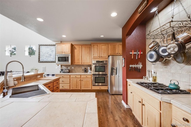 13324 W 86th Dr, Arvada, CO 80005 - kitchen featuring appliances with stainless steel finishes, tile counters, a sink, tasteful backsplash, and recessed lighting