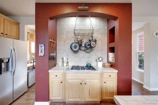 13324 W 86th Dr, Arvada, CO 80005 - kitchen with stainless steel appliances, tile countertops, light wood-type flooring, and backsplash