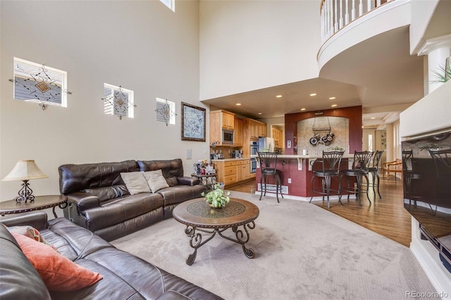 13324 W 86th Dr, Arvada, CO 80005 - living area featuring a towering ceiling, wood finished floors, and baseboards