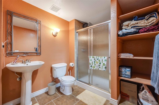13324 W 86th Dr, Arvada, CO 80005 - full bathroom with a stall shower, toilet, baseboards, tile patterned flooring, and a textured wall