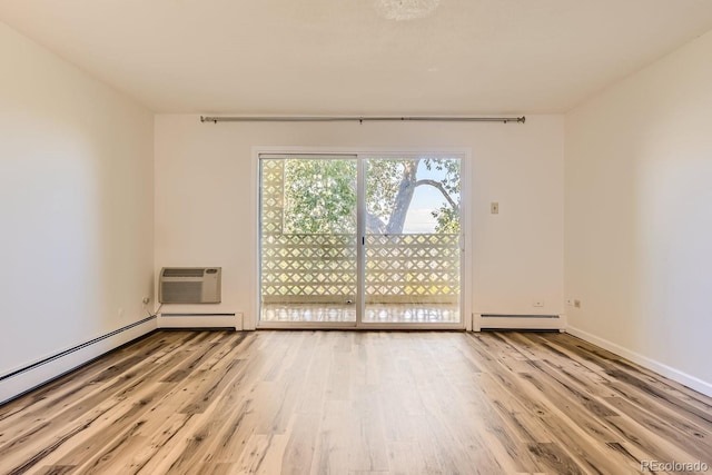 unfurnished room featuring baseboard heating, a wall unit AC, and light wood-type flooring