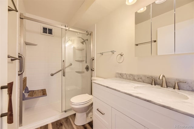 bathroom featuring a shower with shower door, wood-type flooring, toilet, and vanity