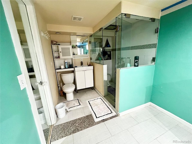 bathroom featuring walk in shower, vanity, toilet, and tile patterned floors