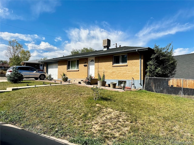 view of front of property featuring a front lawn, cooling unit, and a garage