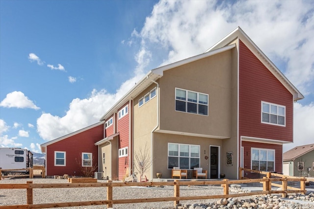 view of front of property with a residential view, fence, and stucco siding