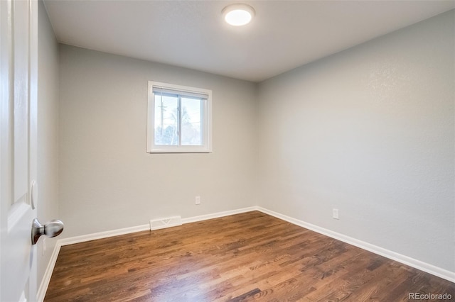 unfurnished room featuring visible vents, baseboards, and wood finished floors