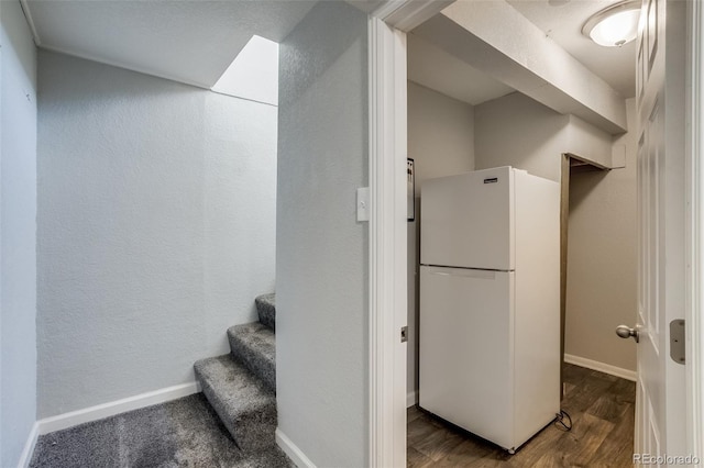 interior space with baseboards, wood finished floors, and a textured wall