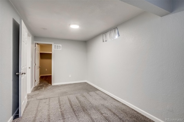 interior space featuring baseboards, visible vents, and a textured wall