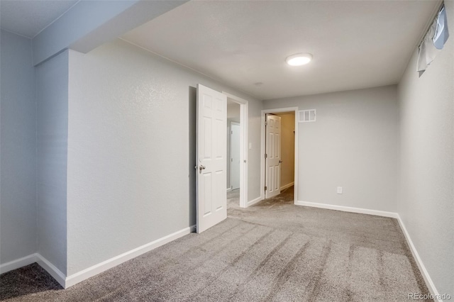 empty room featuring carpet flooring, visible vents, and baseboards