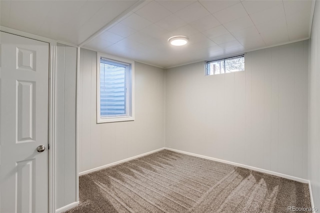 below grade area featuring baseboards and carpet flooring