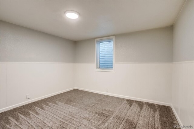 carpeted spare room with wainscoting