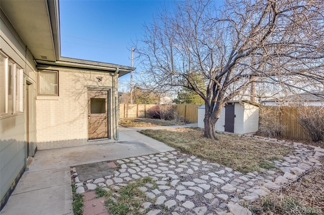 view of yard with a storage shed, a fenced backyard, a patio area, and an outdoor structure