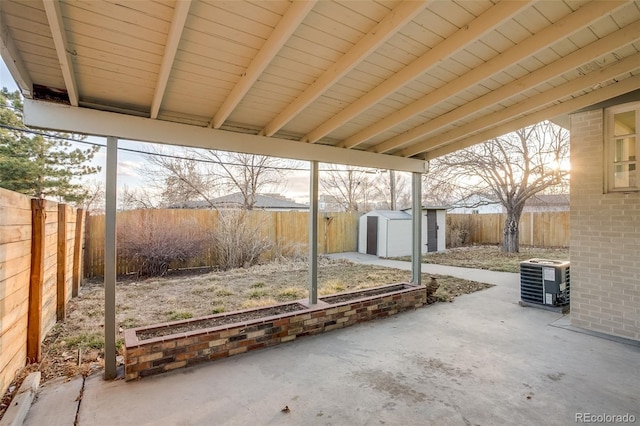 view of patio with central air condition unit, a storage shed, a fenced backyard, and an outdoor structure