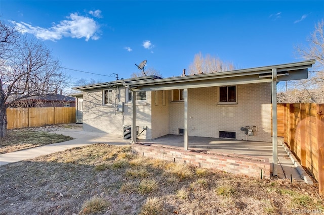 back of property featuring a patio, brick siding, cooling unit, and fence private yard