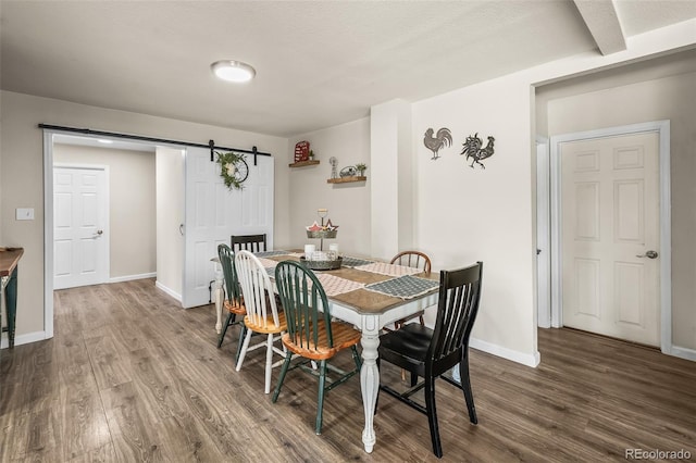 1775 Longbranch St, Strasburg, CO 80136 - dining space featuring a barn door and wood finished floors