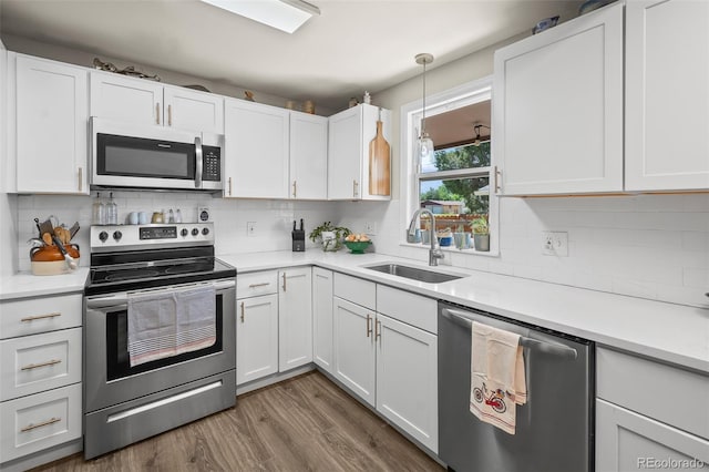 1775 Longbranch St, Strasburg, CO 80136 - kitchen featuring stainless steel appliances, white cabinetry, tasteful backsplash, and dark wood-style flooring