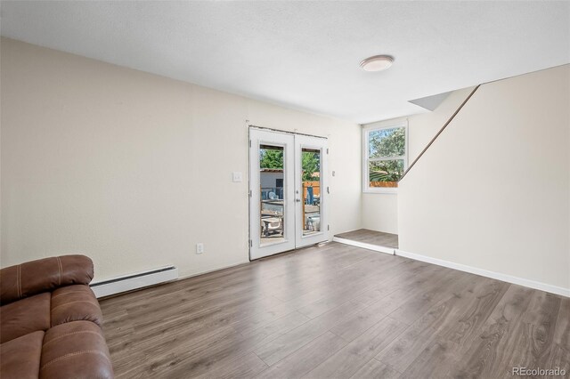 1775 Longbranch St, Strasburg, CO 80136 - living area featuring a baseboard heating unit, wood finished floors, and french doors