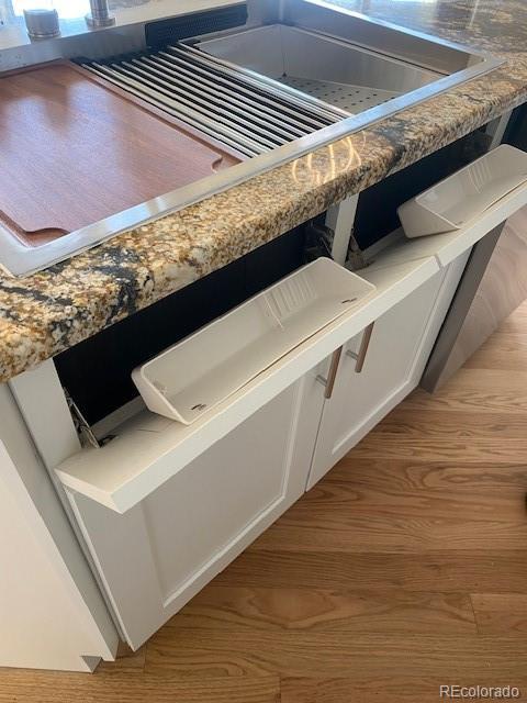 interior details with white cabinetry and light wood-type flooring