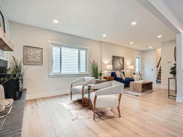 living area featuring light wood finished floors, recessed lighting, stairs, and a wealth of natural light