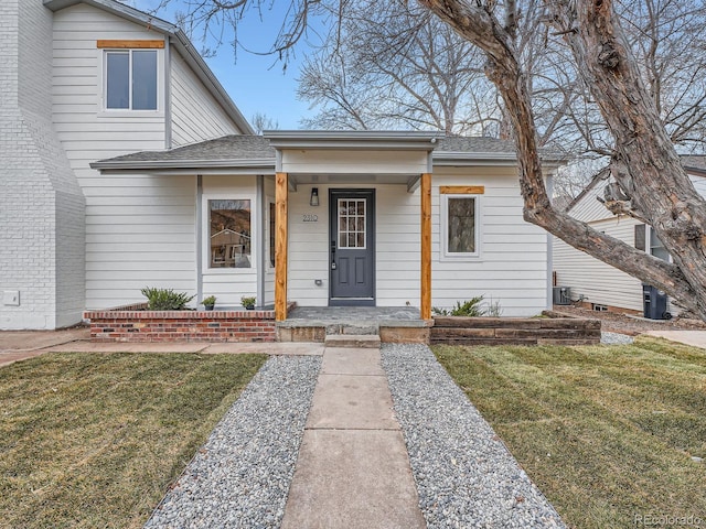 bungalow-style home featuring a porch, roof with shingles, and a front yard