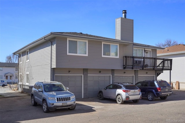 322 21st Ave, Longmont, CO 80501 - view of front facade featuring driveway, a chimney, and an attached garage