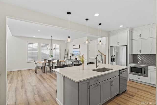 11103 Cloud Shadow St, Littleton, CO 80125 - kitchen featuring appliances with stainless steel finishes, recessed lighting, gray cabinetry, tasteful backsplash, and light wood-style flooring