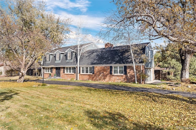 cape cod house with a front yard