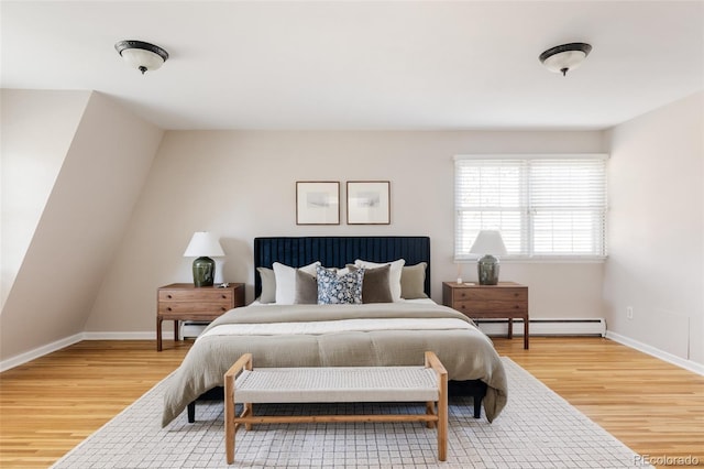 bedroom with hardwood / wood-style floors and baseboard heating