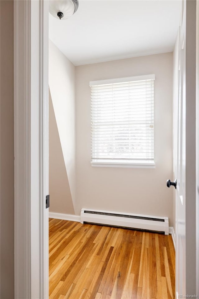 empty room with a baseboard radiator and wood-type flooring