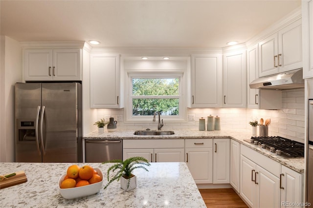 kitchen with sink, light stone countertops, tasteful backsplash, white cabinetry, and stainless steel appliances